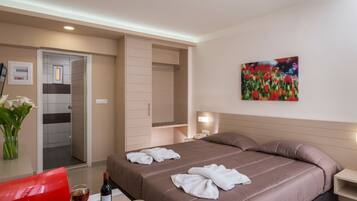 A hotel room with a bed, bedside table, and a painting on the wall.