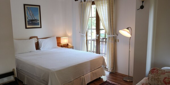 A neatly made bed with white linens, a bedside lamp, and a framed picture on the wall. - Efe Hotel Göcek (Fethiye)