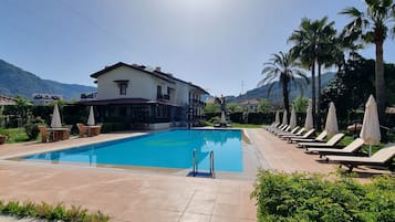 Una piscina al aire libre de temporada, camas de piscina gratis