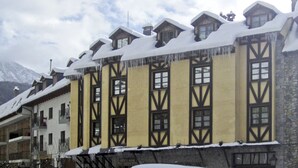 A traditional chalet-style building with multiple windows and a snow-covered roof. - San Marsial Benasque Hotel&Apartamentos (Benasque)