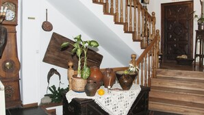 A staircase with wooden balusters, a wall-mounted clock, and a door with a decorative panel. - San Marsial Benasque Hotel&Apartamentos (Benasque)
