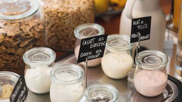 A variety of food items on a tray, including jars of yogurt and other dairy products, with labels indicating flavors like Greek yogurt and fruit yogurt.