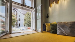 A room with a bed, a window, and a wall-mounted speaker. - Casa Luxemburg (Sibiu)