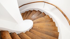 A wooden spiral staircase with a white handrail and wall. - Casa Luxemburg (Sibiu)