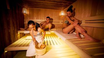 A sauna with wooden benches and benches, a wooden bucket, and a wooden spoon.