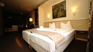 Una habitación de hotel con una cama grande, un escritorio, una lámpara y un cuadro en la pared.