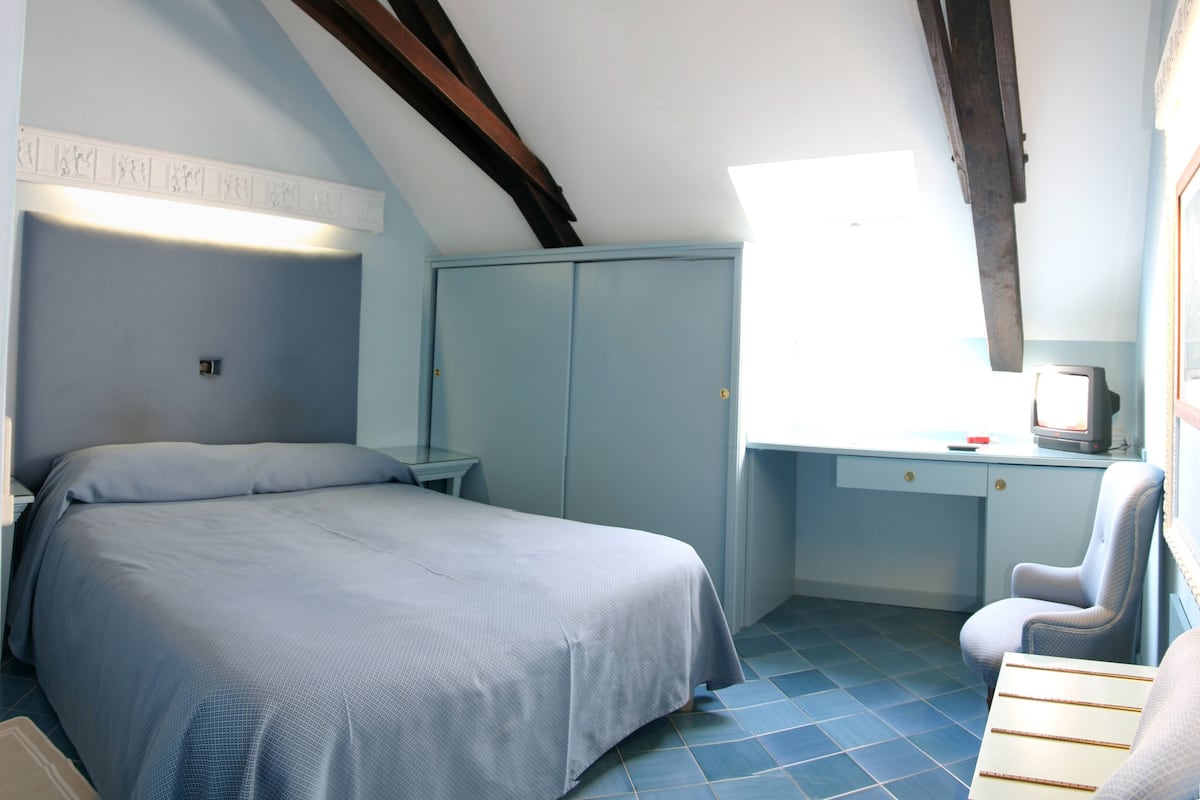 Ein Schlafzimmer mit einem Bett, einem Schreibtisch und einem Stuhl.