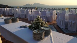 A terrace with round tables set for a wedding, overlooking a scenic view. - Hotel Villa Pina Antico Francischiello (Massa Lubrense)