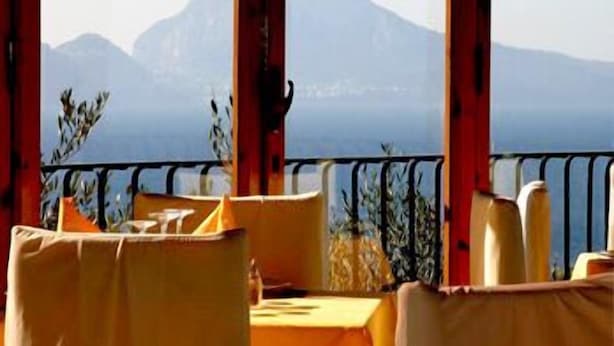 A restaurant with outdoor seating, a view of mountains, and a railing. - Hotel Villa Pina Antico Francischiello (Massa Lubrense)