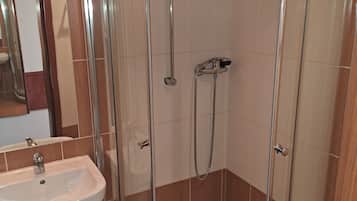 A modern bathroom with a glass-enclosed shower, a sink, and a mirror.