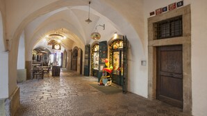 A narrow, cobblestone corridor with arched ceilings and a wooden door on the right. - Pension Corto (Prague)