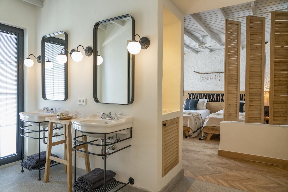 Une salle de bain moderne avec deux lavabos, de grands miroirs et un meuble-lavabo en bois.