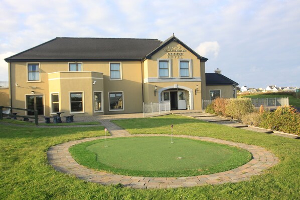 A hotel with a well-maintained lawn and a brick pathway leading to the entrance. - Vaughan Lodge Hotel (Lahinch)
