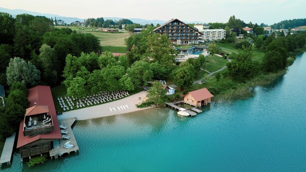 Hotel con piscina, muelle y zona de estar al aire libre junto al lago.