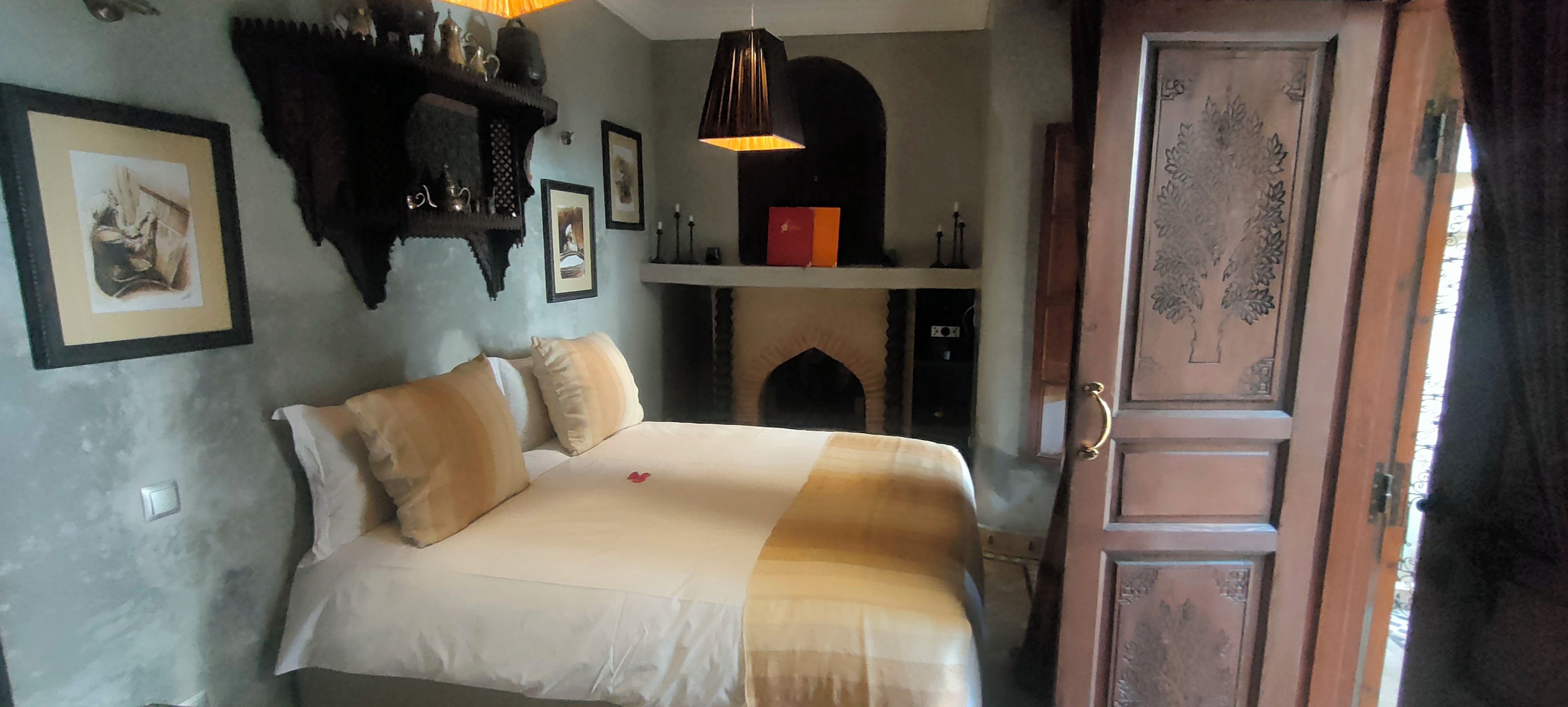 A bedroom with a bed, a fireplace, and a door.