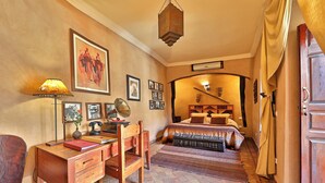 A bedroom with a wooden desk, chair, and bed.