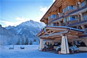 A hotel with a wooden facade, balconies, and a sign reading "PEGRA HOTEL". - Hotel Garnì Pegrà (Ponte di Legno)
