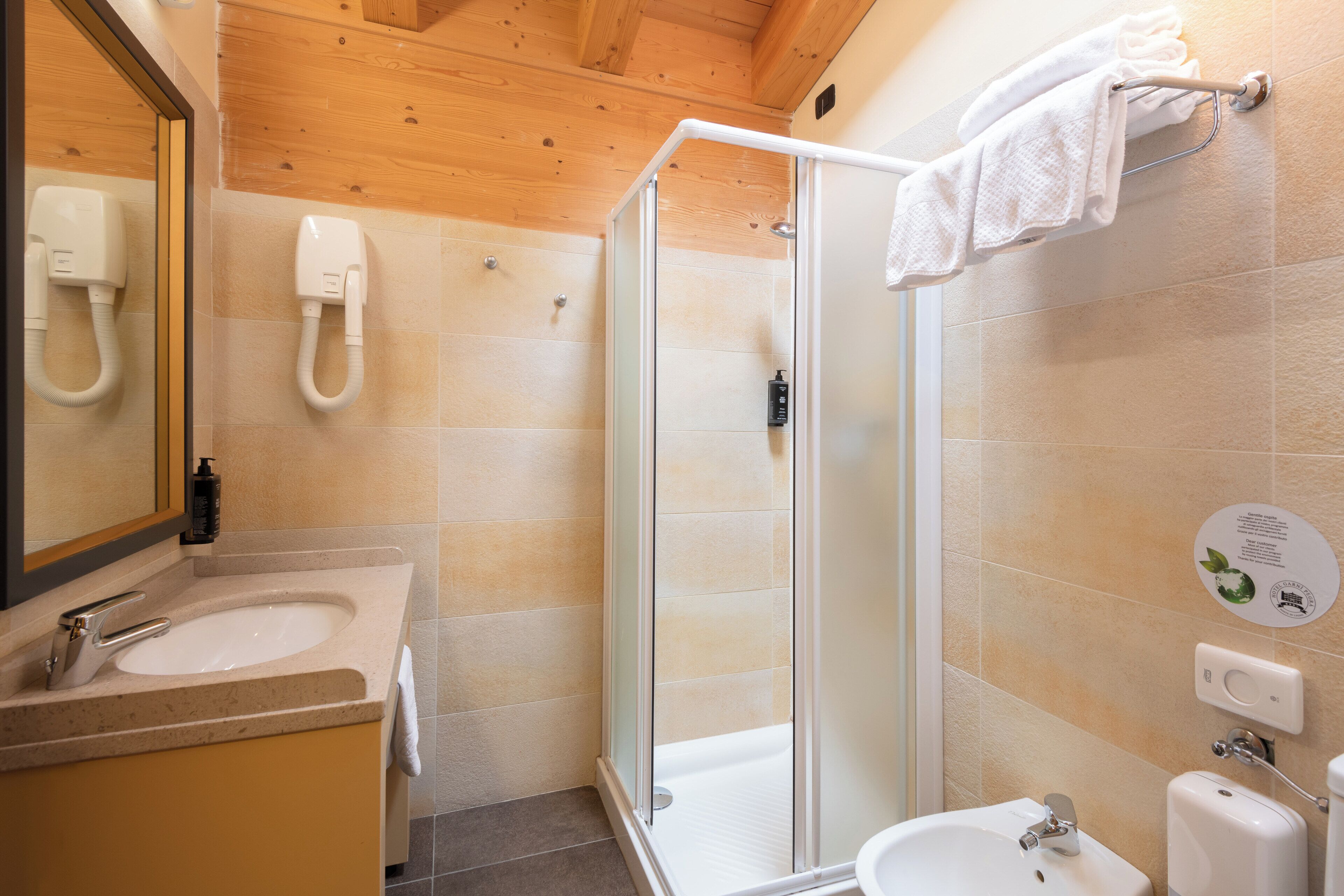 Un baño moderno con cabina de ducha de vidrio, un lavabo y un espejo.
