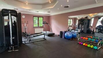 A gym with exercise equipment, treadmills, and kettlebells.