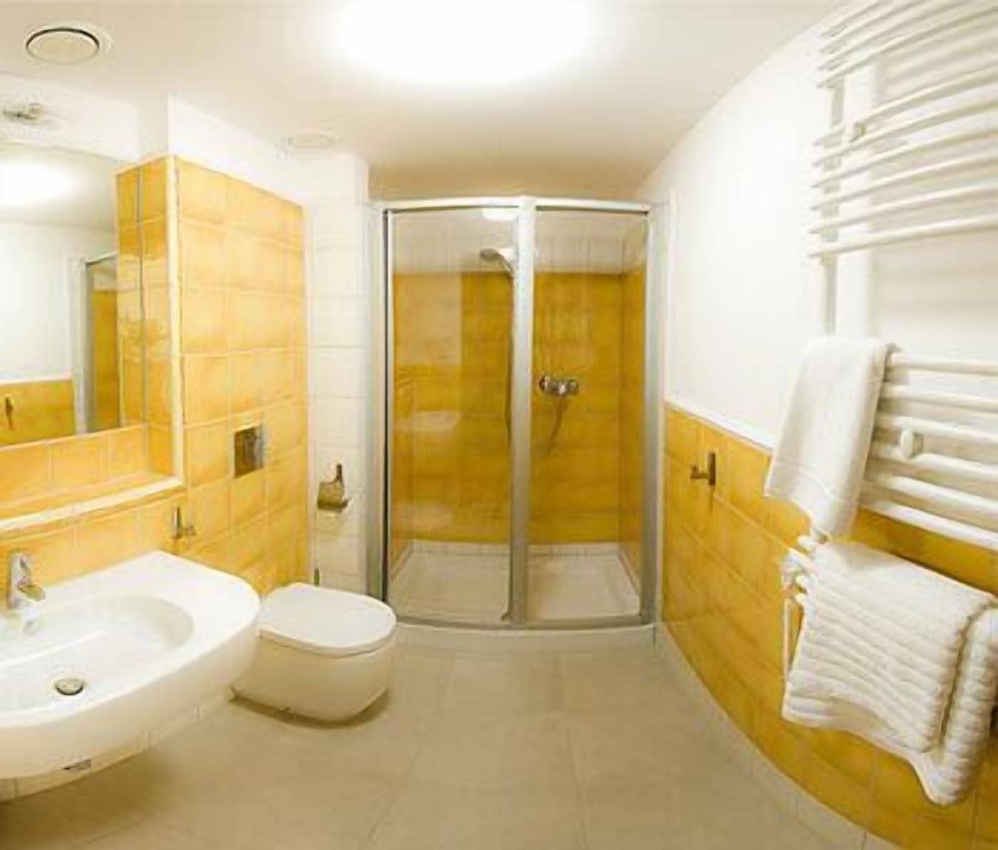 A bathroom with a shower, sink, and toilet.
