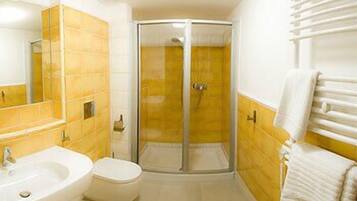 A bathroom with a shower, sink, and toilet.