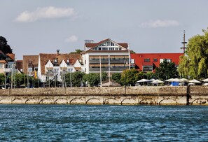 A waterfront building with multiple floors, a red roof, and a balcony. - Seehotel Litz (Langenargen)