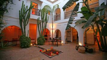 A spacious courtyard with a central water feature, surrounded by cacti and potted plants.