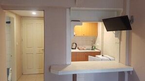 Una cocina con encimera blanca, un lavabo y armarios de madera.