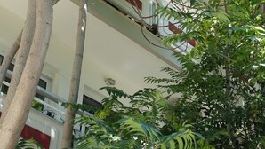 Un edificio de varios pisos con balcones y árboles en la fachada.