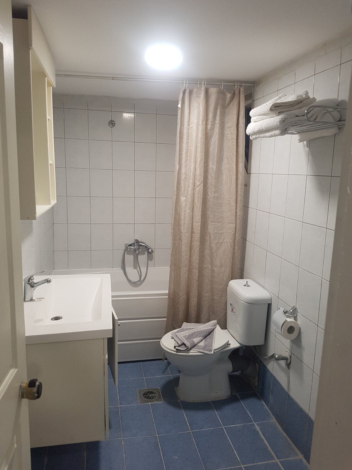 Un bagno piccolo con vasca, water e lavandino.