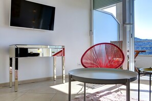 Apartamento superior, sacada, vista para o mar | Ărea de estar | TV de tela plana 50 polegadas com canais via satĂ©lite, TV LCD