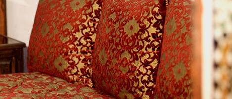 Uma cama com um edredom estampado e duas almofadas decorativas.