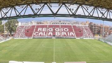Uno stadio con una vasta area di posti a sedere vuota e un campo da gioco.