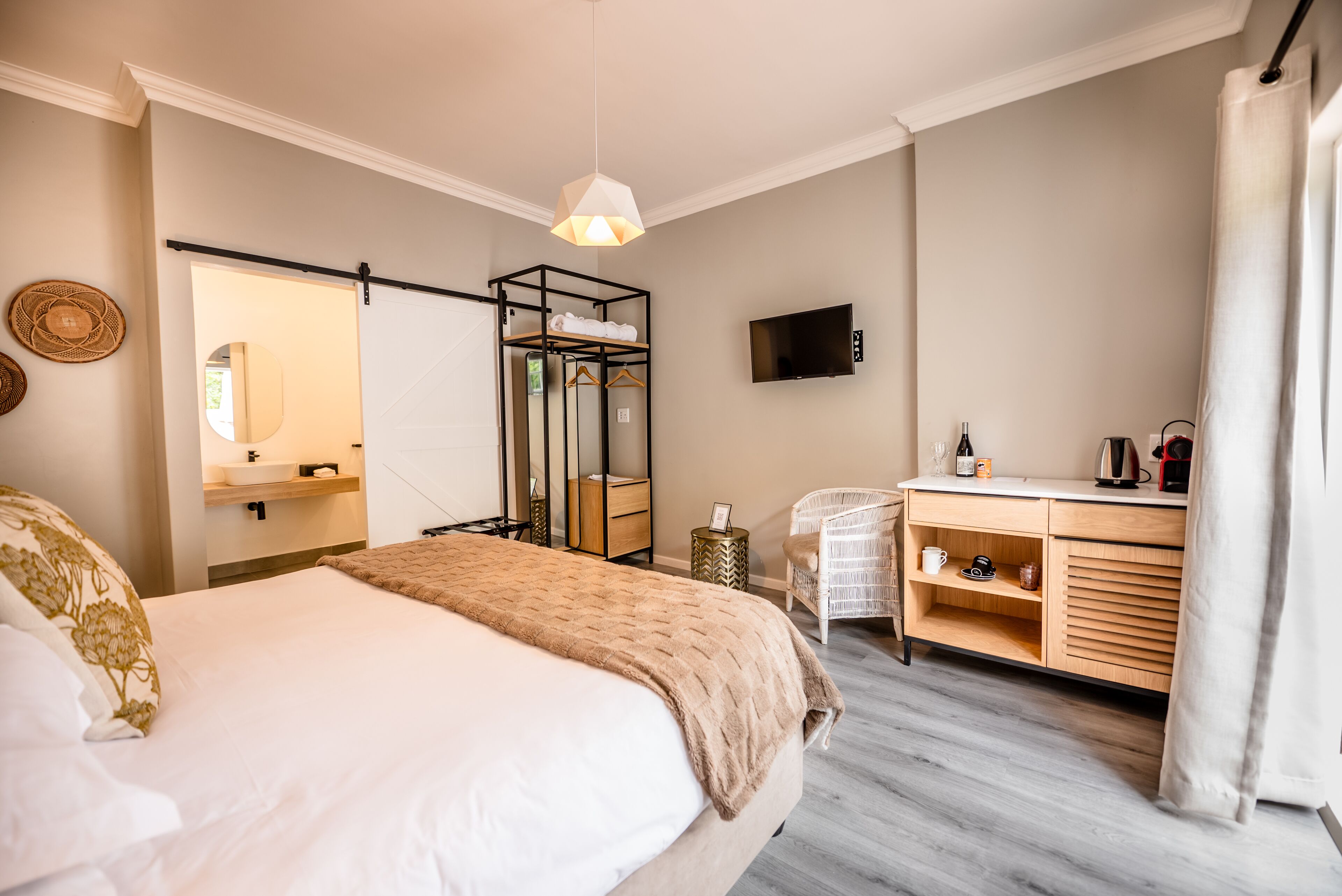 A modern bedroom with a bed, bedside table, and a desk area with a chair.