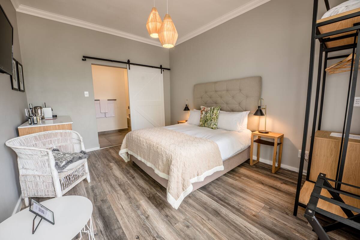 A bedroom with a bed, bedside tables, a chair, and a wardrobe.