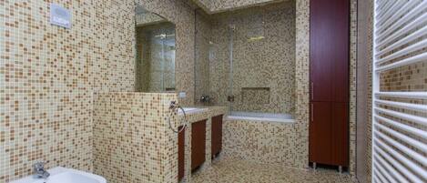 A bathroom with mosaic tile walls, a sink, a mirror, and a bathtub.