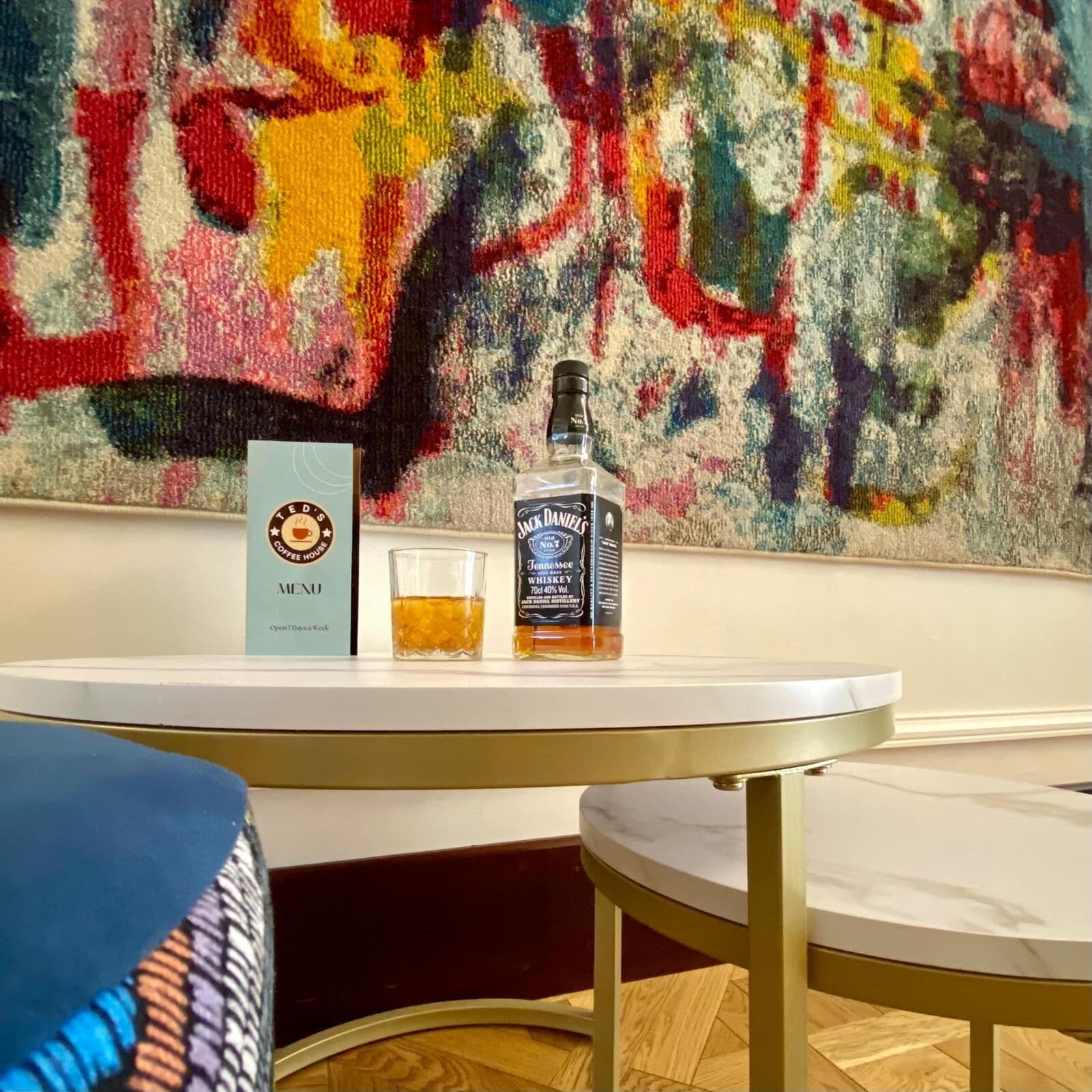 Una mesa con un menú, una botella de Tennessee Whiskey Jack Daniel's y una copa de whiskey.