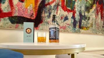 Una mesa con un menú, una botella de Tennessee Whiskey Jack Daniel's y una copa de whiskey.