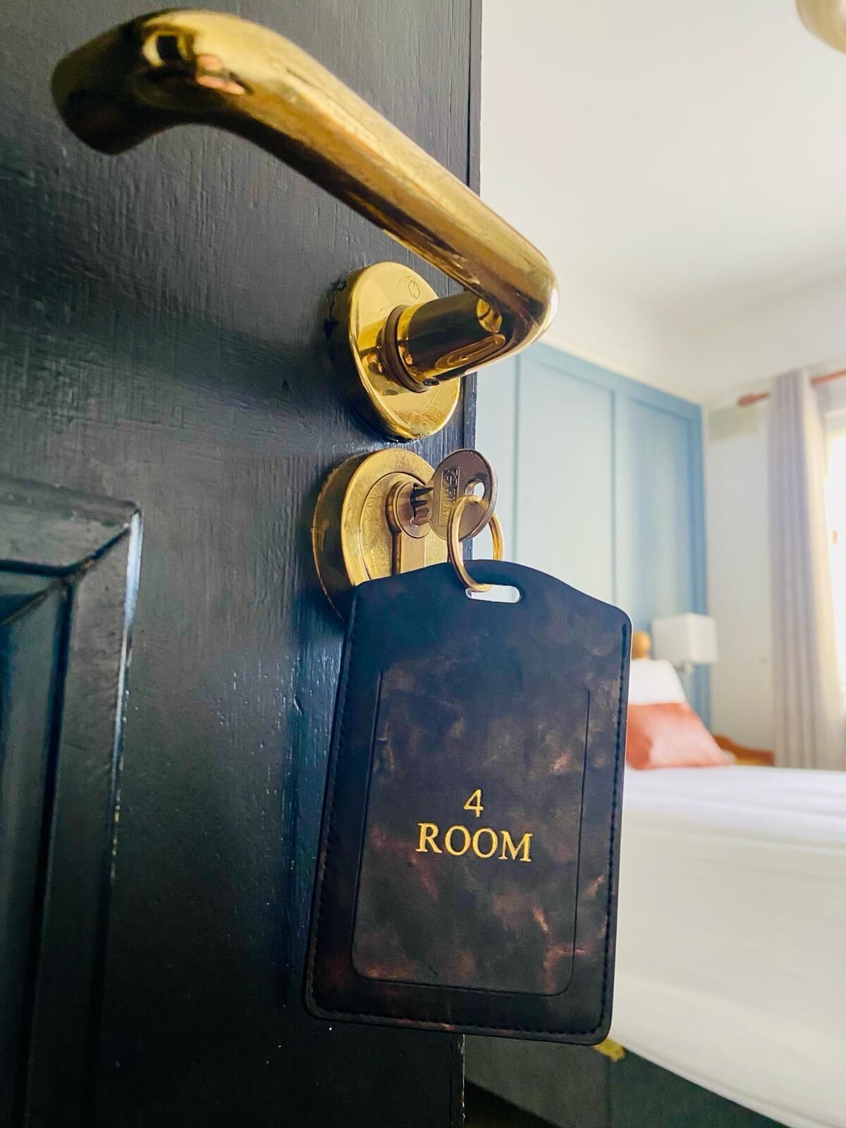 A door with a brass handle, a keyhole, and a room number tag indicating "4 ROOM".