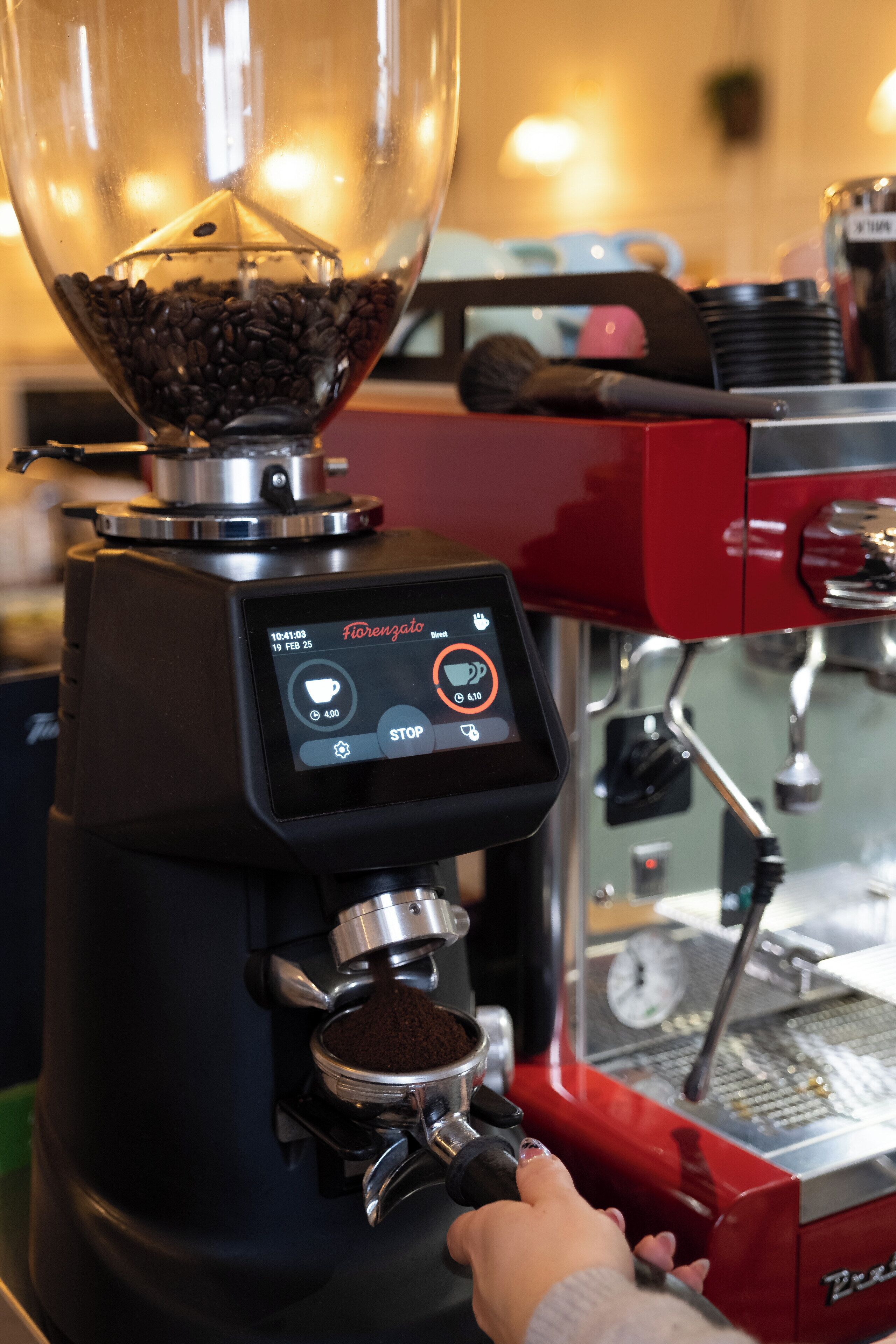 A coffee machine with a digital display, a coffee cup icon, and a "STOP" button.