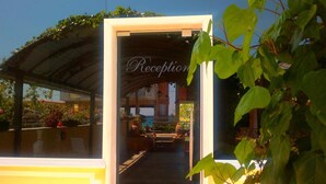 A reception area with a covered entrance, potted plants, and a view of the street. - Pfaffenhofen (Volvi)