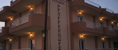 A multi-story building with balconies and a sign reading "Pension Franzloper".
