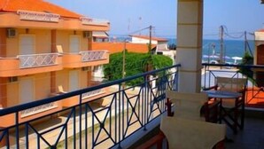 A hotel balcony with a view of the sea, featuring a railing and a table with chairs. - Pfaffenhofen (Volvi)