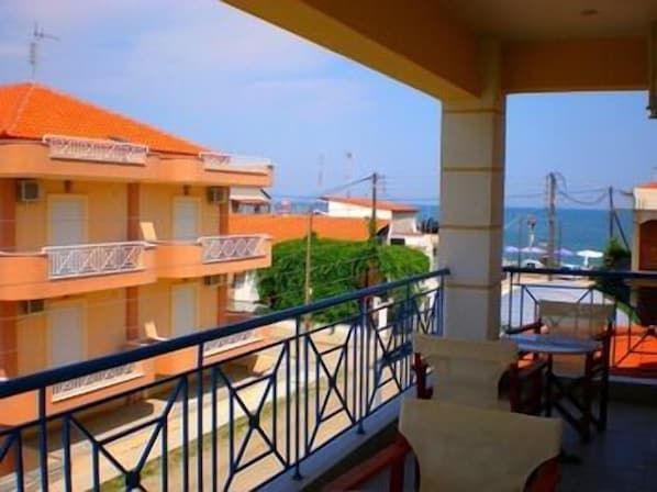 A hotel balcony with a view of the sea, featuring a railing and a table with chairs. - Pfaffenhofen (Volvi)