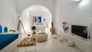 Una sala de estar moderna y minimalista con un sofá, televisor y elementos decorativos.