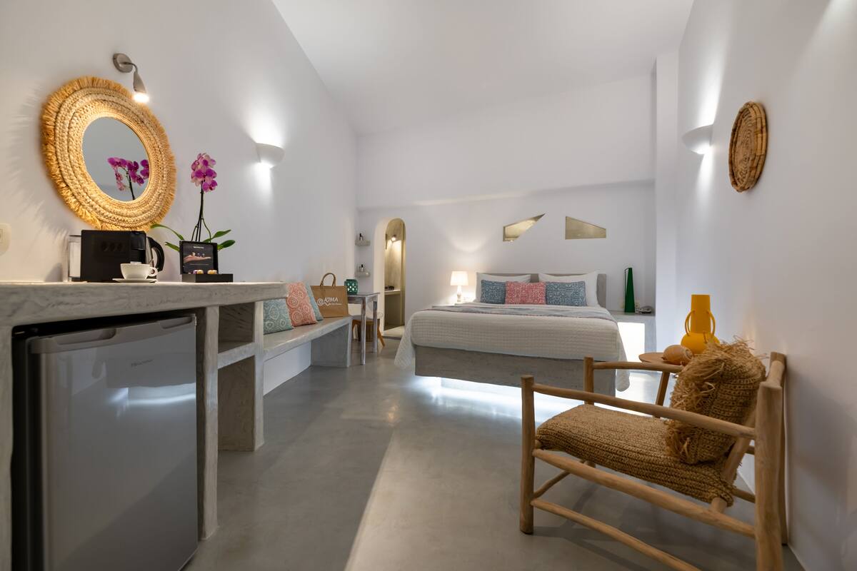 A modern bedroom with a bed, bedside table, and a small kitchenette.