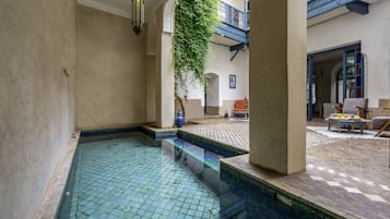 Una piscina techada, sillones reclinables de piscina