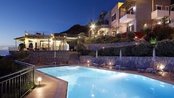 Una piscina al aire libre de temporada, sombrillas