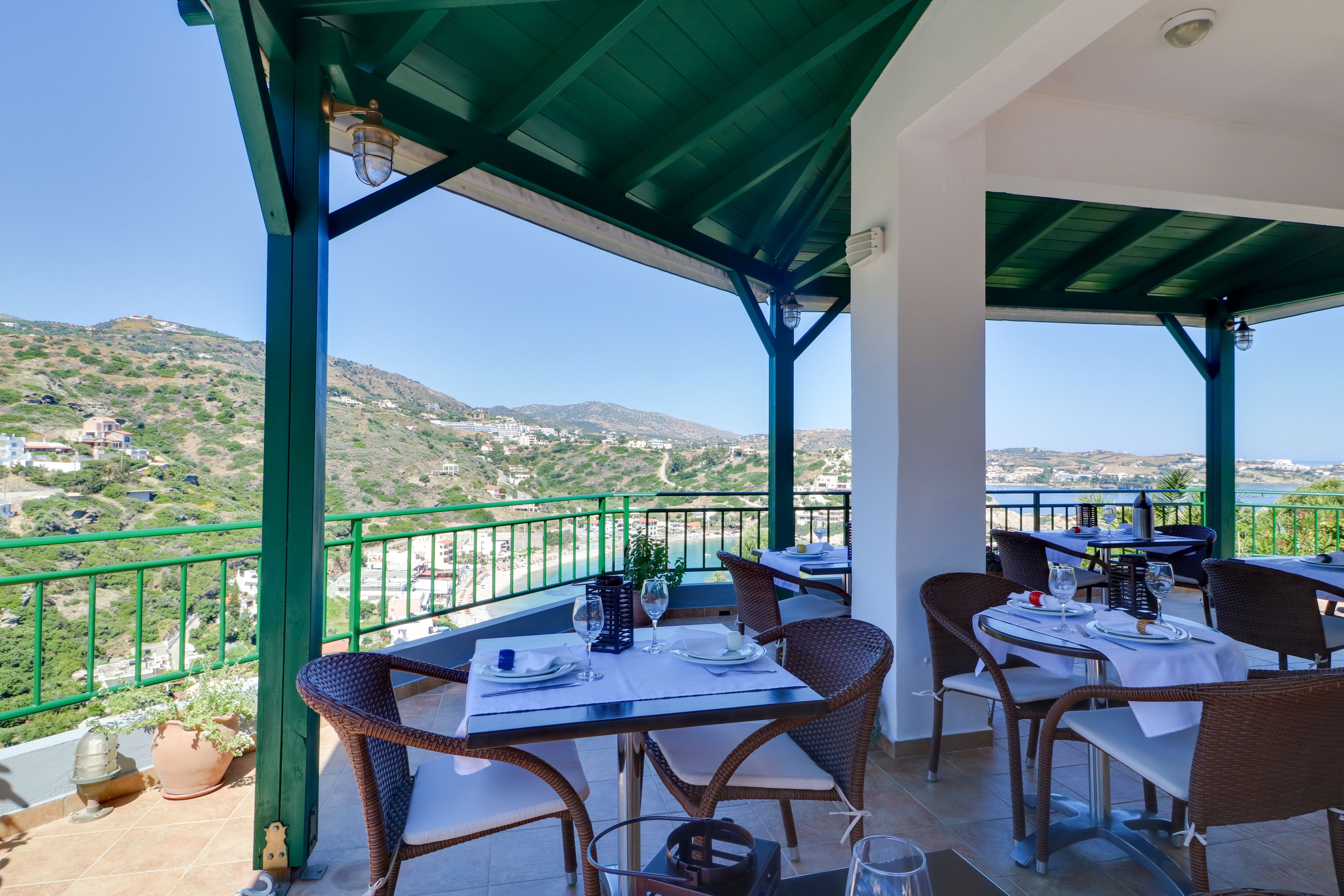 Une terrasse dotée de tables et de chaises, offrant une vue sur un paysage montagneux.
