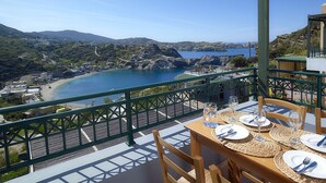 A table set for dining with a view of a coastal landscape.